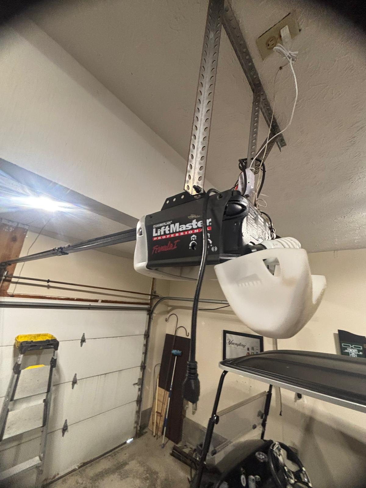 LiftMaster chain-drive garage door opener mounted to a garage ceiling with its rail in place.